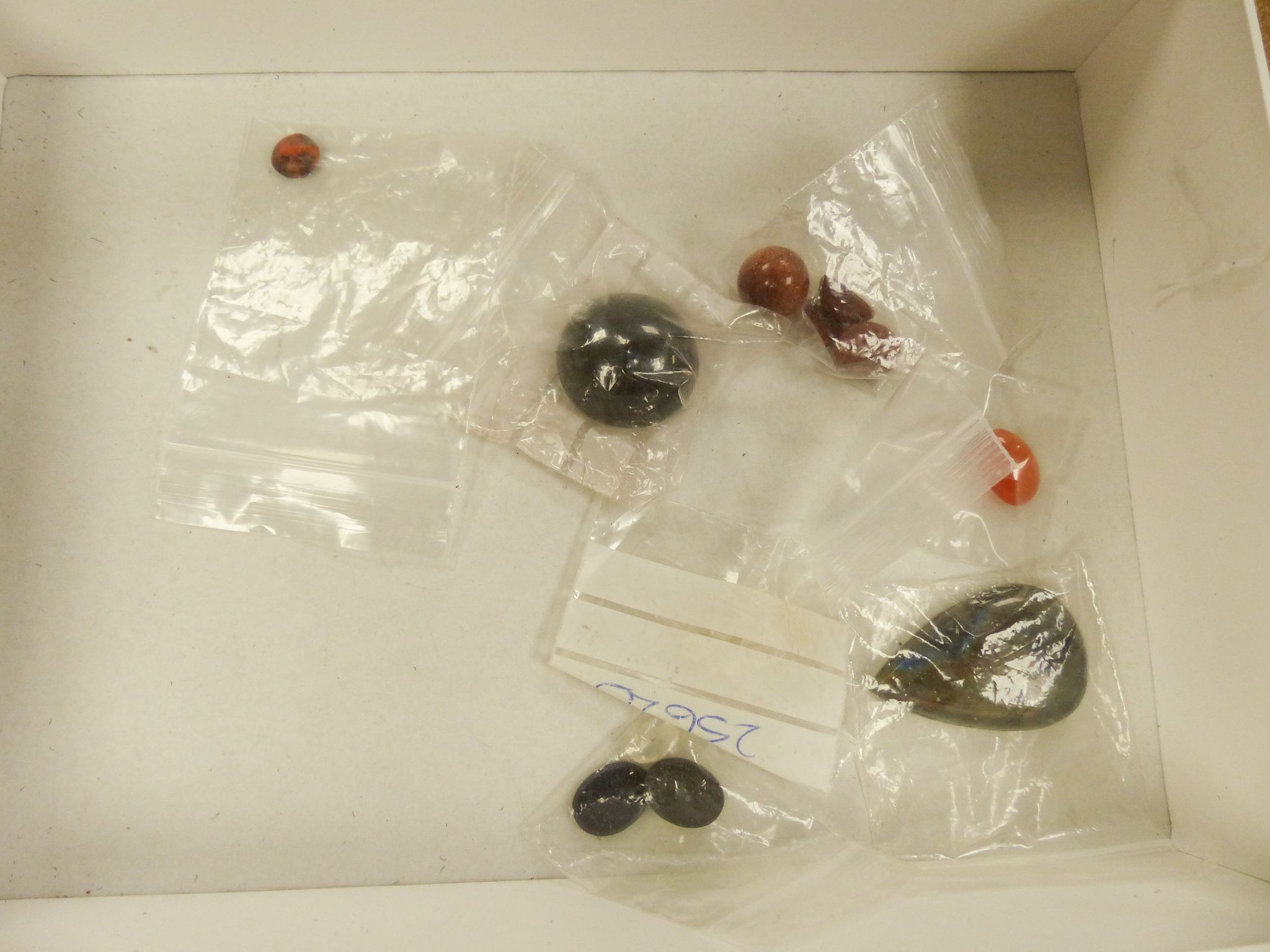 A quantity of assorted unmounted gemstones including, opal, opal doublet, malachite, chalcedony, tiger's eye quartz, hematite, etc.